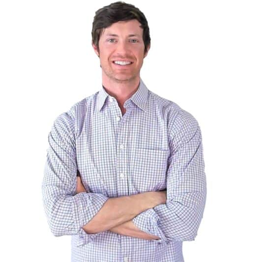 dr. westin childs smiling with his arms crossed in a button up shirt.